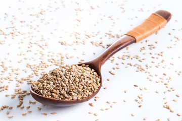 Rolled oats on wooden spoon isolated on white background, healthy breakfast cereal oat flakes 