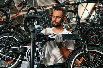 Professional occupation. Repair man in bicycle shop, working in store