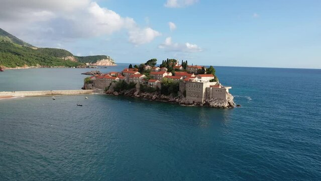 Amazing Aerial around view of Sveti Stefan resort island in Montenegro, 4k, drone video. The small old town of Sveti Stefan and resort in Montenegro