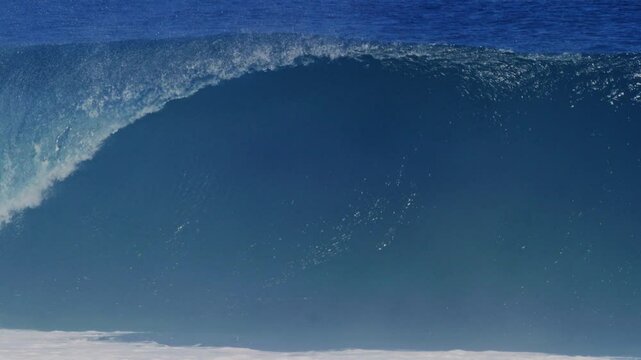 Medium view of textured strong powerful ocean water rising into wave with mist flying off top