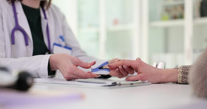 Doctor puts pulse oximeter on patient finger at appointment