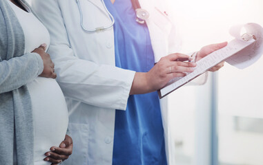 Hands, pregnant woman and doctor with clipboard, prenatal checkup and appointment for healthcare. Closeup, pregnancy and patient with tummy, medical professional and insurance paperwork insurance