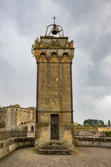 Fototapeta premium A glimpse of the ancient medieval village of Sorano, on a melancholy and rainy spring day. In the province of Grosseto, Tuscany, Italy. The old houses built in stone and tuff bricks.
