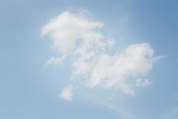 Image of a sky with white clouds and green mountains.