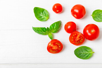 Fototapeta premium Fresh cherry tomatoes and fresh green basil on a textured background. Tomato sauce. Vegan. Ingredients for salad. Organic food. Place for text. Copy space.