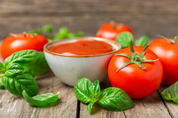 Fresh cherry tomatoes and fresh green basil on a textured background. Tomato sauce. Vegan. Ingredients for salad. Organic food. Place for text. Copy space.