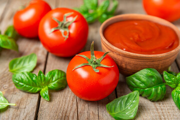 Fresh cherry tomatoes and fresh green basil on a textured background. Tomato sauce. Vegan. Ingredients for salad. Organic food. Place for text. Copy space.