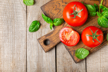 Fresh cherry tomatoes and fresh green basil on a textured background. Tomato sauce. Vegan. Ingredients for salad. Organic food. Place for text. Copy space.