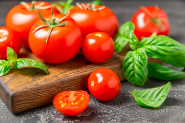 Fresh cherry tomatoes and fresh green basil on a textured background. Tomato sauce. Vegan. Ingredients for salad. Organic food. Place for text. Copy space.
