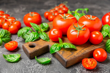 Fresh cherry tomatoes and fresh green basil on a textured background. Tomato sauce. Vegan. Ingredients for salad. Organic food. Place for text. Copy space.