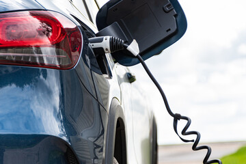 Close up of an EV battery electric car plugged in on charge with a granny cable slow charge from...