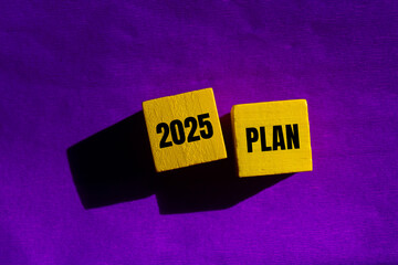 2025 plan message written on yellow wooden cubes with purple background. Conceptual 2025 plan symbol. Copy space.