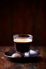 Coffee in glass cup on dark background. Close up. Copy space.	