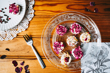 Petits fromages de chèvre frais avec des graines et pétales fait-maison posés dans une assiette