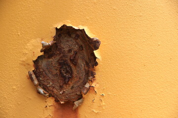 The steel wall is very old, rusted, peeled, cracked and dirty.