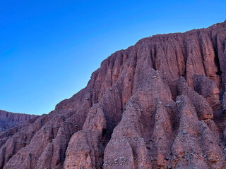 Red crumbling mountains in the Jujuy region on a sunny day, Argentina
