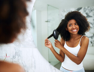 Black woman, painful and brush in mirror for haircare, daily routine and morning styling for knot control or self care. Girl, cosmetic product and reflection at home, afro and natural hair repair