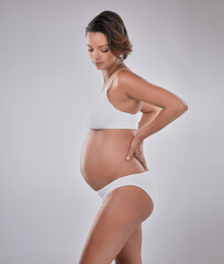 Fototapeta premium Woman, pregnant and love on white background with thinking for child wellness, mama with hope for future. Female person, planning and studio with wondering for pregnancy, baby health or wellbeing