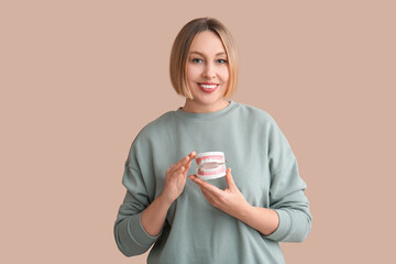 Woman with plastic jaw on beige background