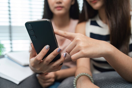 Young Woman Using Smartphone to Follow Online News at Home, Engaging with Digital Media and Staying Informed