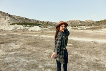 Naklejka premium Serenity in the countryside woman in hat and plaid shirt standing in field on a sunny day