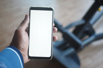 man hand holding green screen smart phone in gym