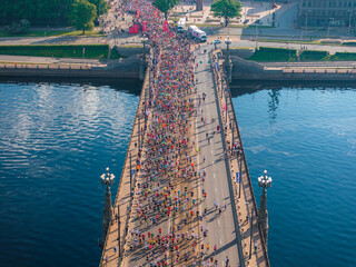 Aerial shot of a dense crowd of marathon runners spanning the length of a bridge in Riga, Latvia....