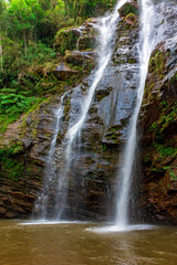 Waterfall inside the dense vegetation of rainforest among the rocks and vegetation in the state of Minas Gerais in Brazil