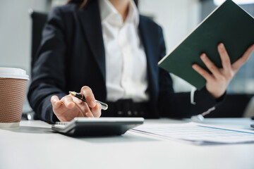 Business and financial concepts about office work. Analysts discuss business with a calculator as a...