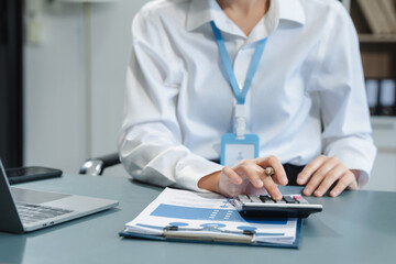 Businesswoman using digital tablet analyzes business data, busy working on laptop computer with smart phone and business report on office desk, business strategy analysis concept.