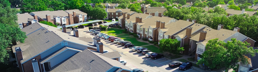 Panorama aerial view large apartment complex with covered parking lots outdoor garage space, Coppell, Texas, rental neighborhood townhouses in Dallas Fort Worth metroplex, suburban housing market
