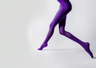 Female legs in purple tights against white studio background, wide length, copy space