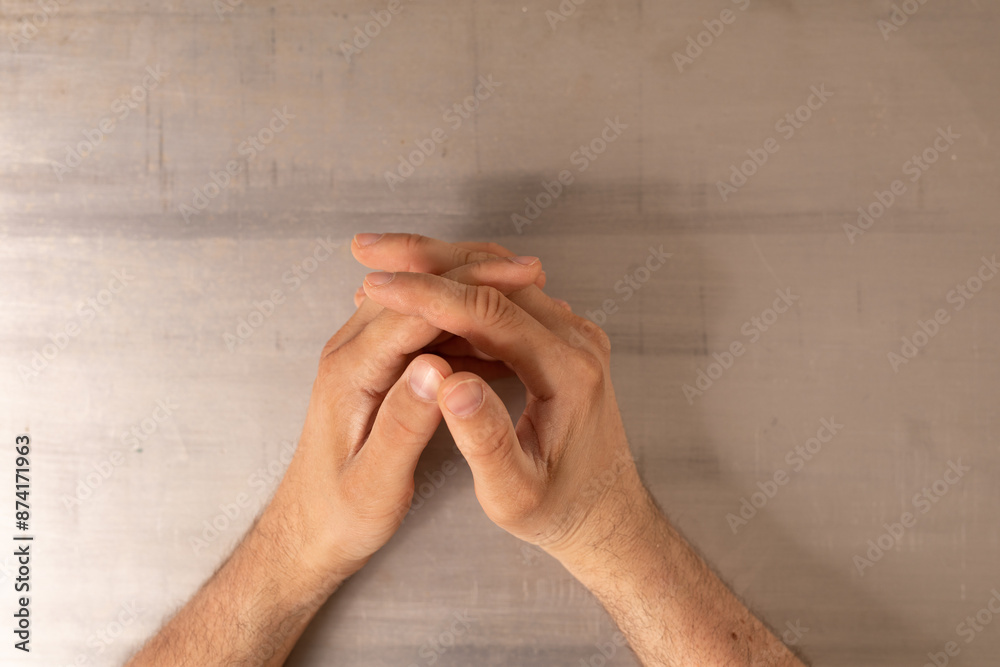 Poster two hands resting on a table their fingers intertwined