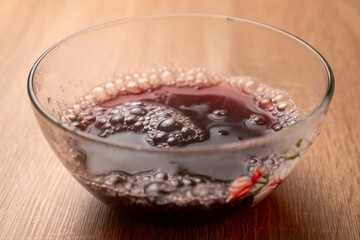 Hot water is poured into a bowl, in which green jelly is dissolved. Preparation of gelatin desserts.