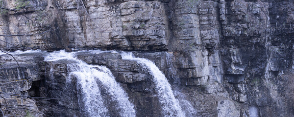 Waterfall running into river in the Rocky mountains