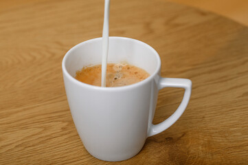 Dolewać mleczko do kawy, izolowane, z bliska © Paweł Kacperek