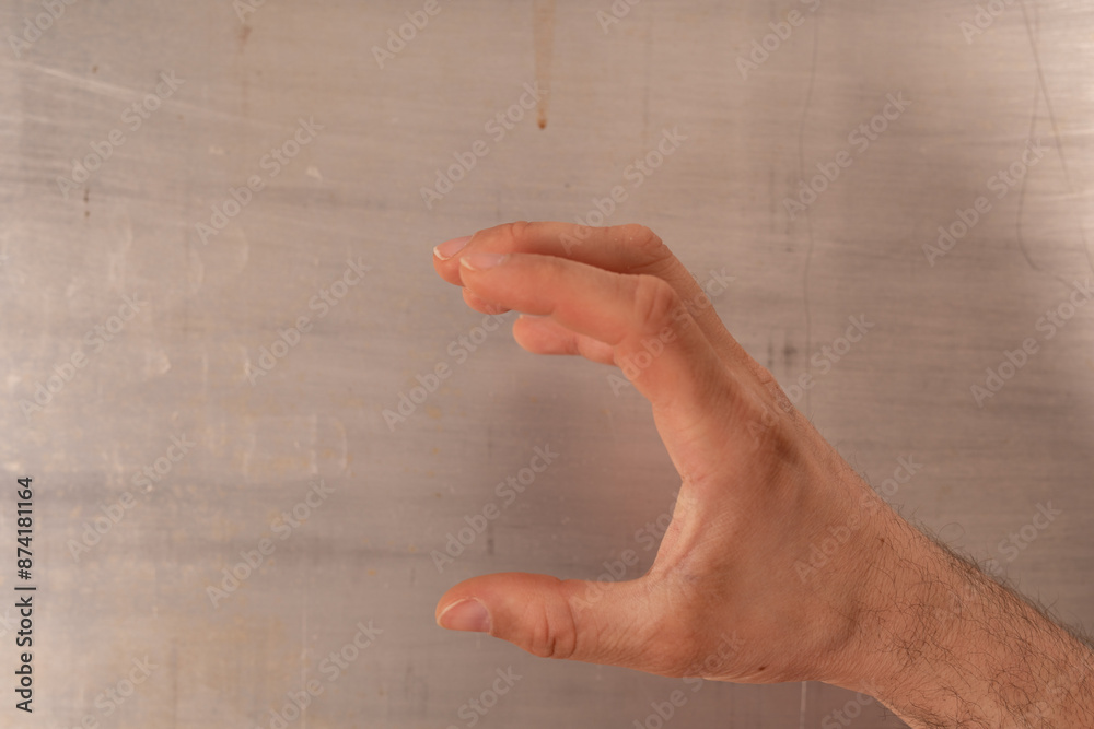 Poster a hand makes a gesture of holding something small