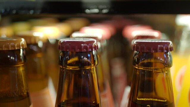 Vintage beverage bottles with colorful caps on bar shelf create a nostalgic retro drinks display
