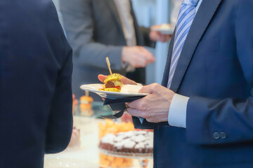 catering buffet food indoor in luxury restaurant with meat and vegetables - Close-up of the hands of a man and a woman holding a plate of food