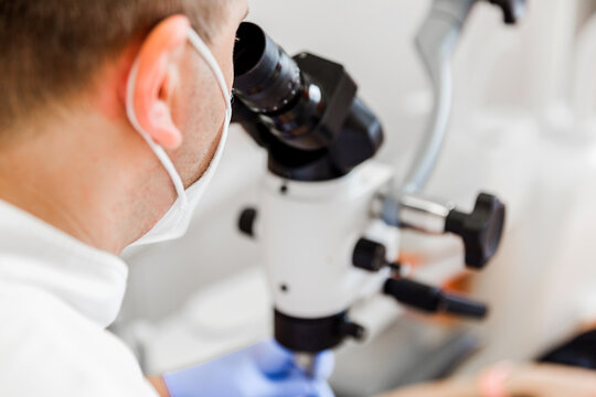 Dentist Using Microscope for Patient Examination