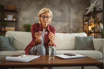 Mature senior woman hold the medicine and prepare to drink them