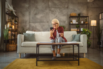 Mature woman hold the medicine and read instructions on mobile phone