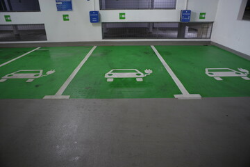 A parking lot with three electric car charging stations