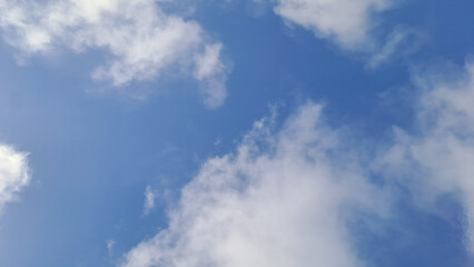 White clouds slowly forming in a calm blue sky