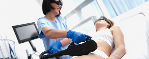 Beautician doing laser hair removal bikini area clients in beauty salon closeup. Beauty services...