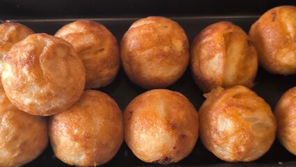 Takoyaki snacks on a black tray, Japanese style food