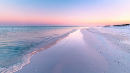 Fototapeta premium A quiet beach with fine, white sand, the sunrise creating a soft, pink glow across the horizon.