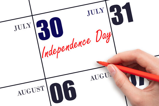 July 30. Hand writing text Independence Day on calendar date. Save the date.