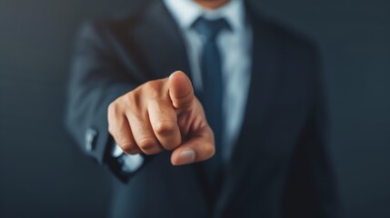 Fototapeta premium Businessman in a suit pointing finger towards the camera, symbolizing choice, selection, or business decision making.