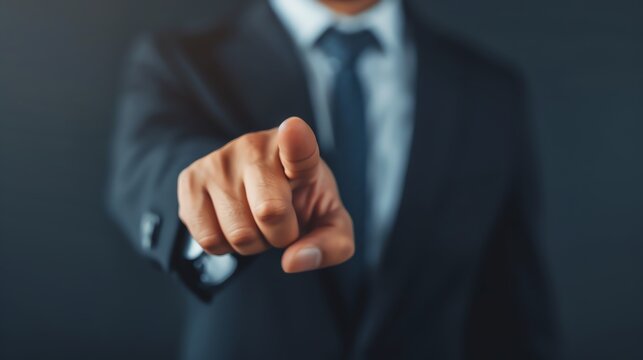 Businessman in a suit pointing finger towards the camera, symbolizing choice, selection, or business decision making.